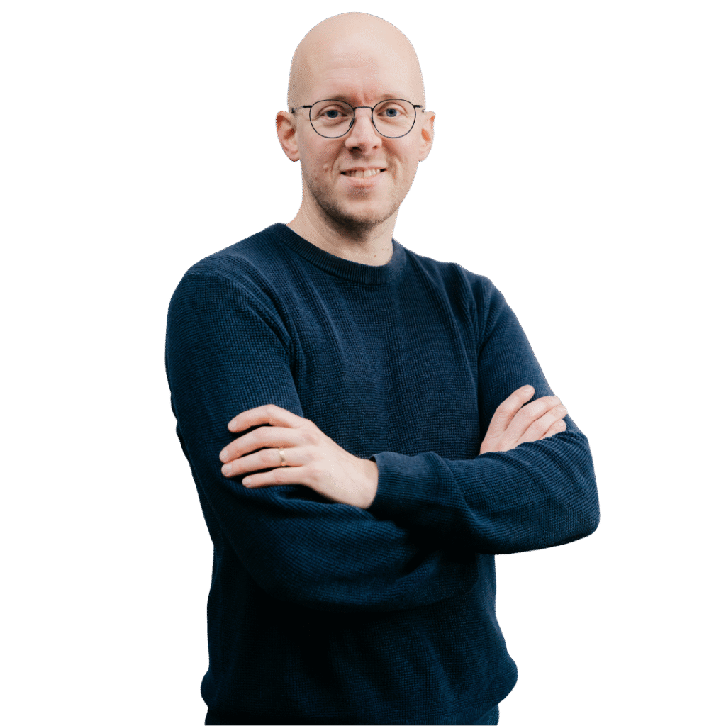 Detailed alt text for SEO: A professional man with glasses and a navy sweater, smiling confidently, symbolizes advanced manufacturing solutions and industry innovation, ideal for Azumuta's manufacturing software content.