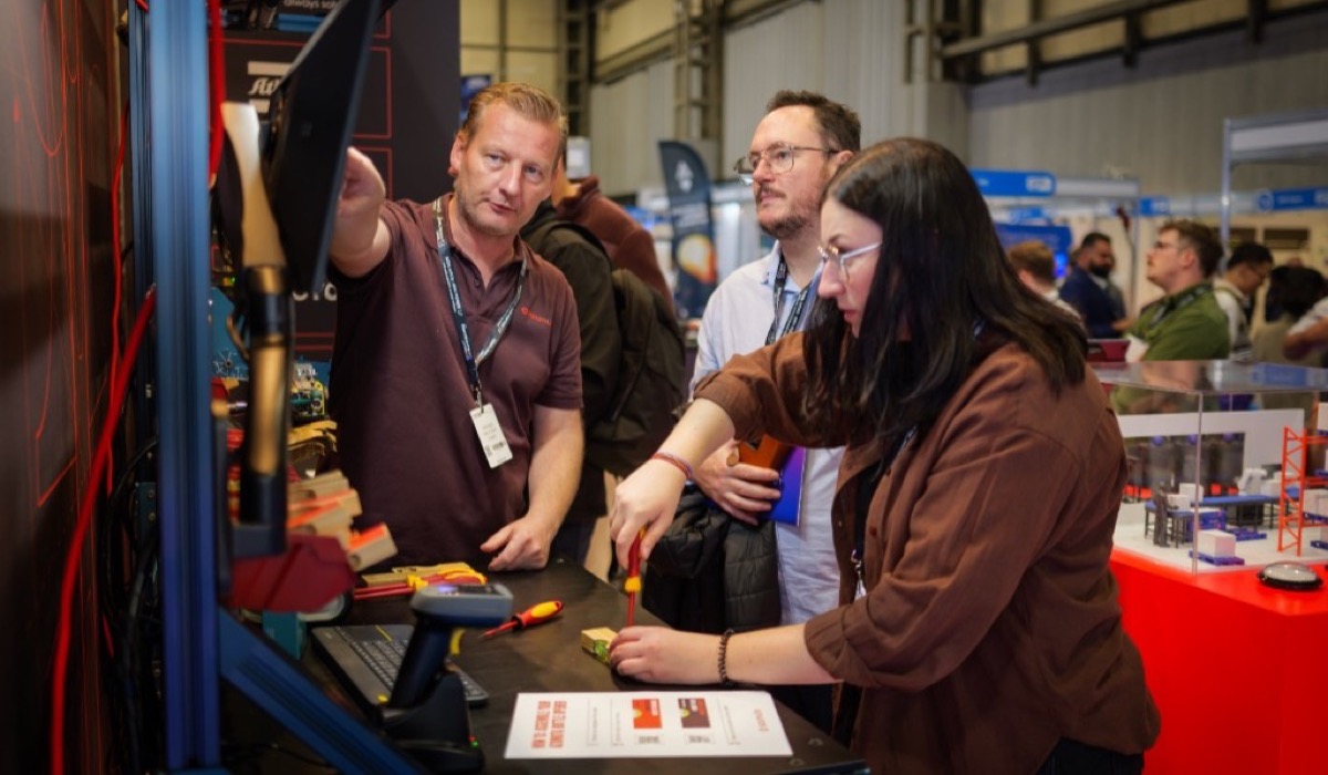 Bezoekers testen digitale werkinstructies en assembleren onderdelen op de Azumuta-stand tijdens Smart Manufacturing Week in Birmingham.